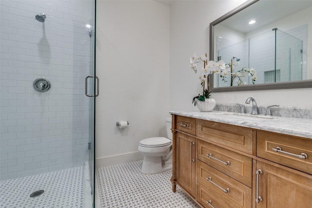 bathroom featuring vanity, baseboards, a shower stall, and toilet