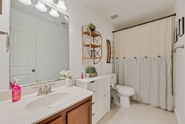 bathroom featuring vanity, tile patterned flooring, toilet, and visible vents