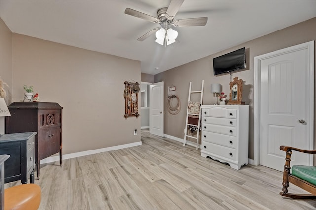 interior space featuring baseboards, a ceiling fan, and light wood-type flooring
