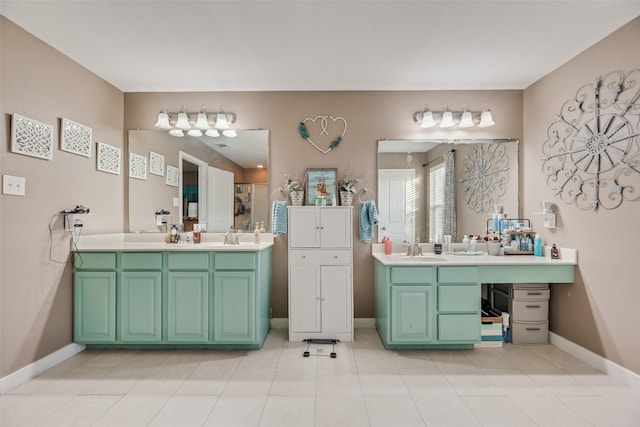 full bath with baseboards, a sink, two vanities, and tile patterned floors