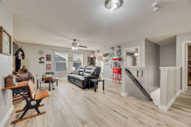living room featuring baseboards, ceiling fan, and light wood-type flooring