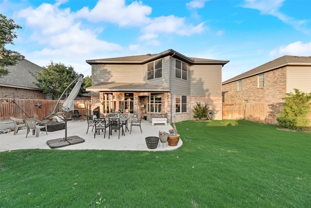 back of property featuring a yard, brick siding, a fenced backyard, and a patio area