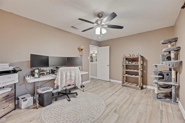 office space with baseboards, ceiling fan, light wood-type flooring, and visible vents