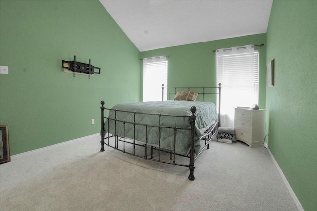 carpeted bedroom with baseboards and vaulted ceiling