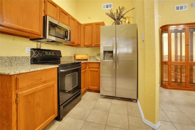 kitchen featuring appliances with stainless steel finishes, light tile patterned flooring, and visible vents