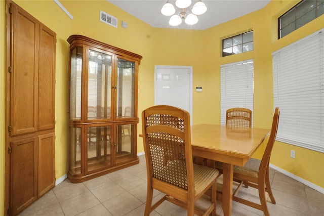 dining area featuring a chandelier, plenty of natural light, baseboards, light tile patterned floors, and visible vents