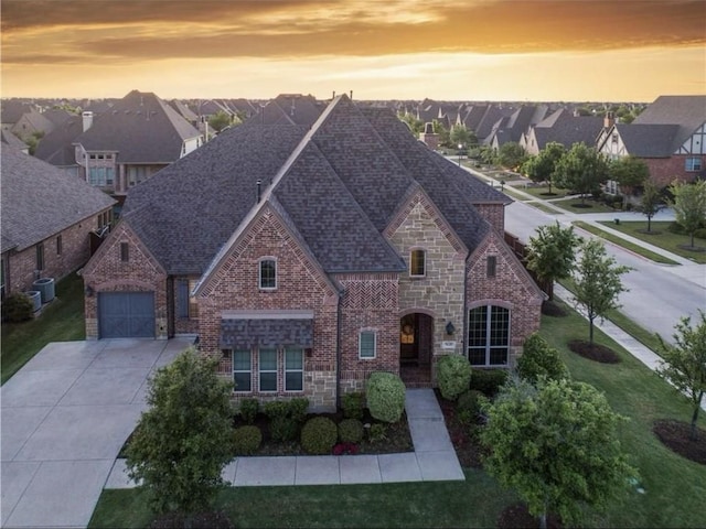 view of front of home featuring a shingled roof, driveway, stone siding, and brick siding