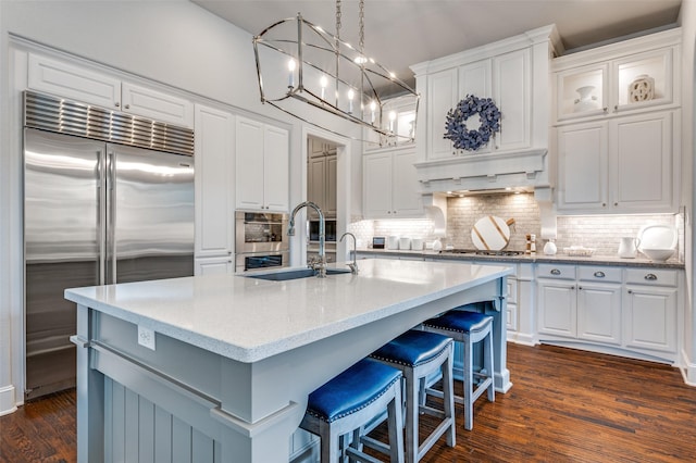 kitchen with stainless steel appliances, white cabinetry, and a sink