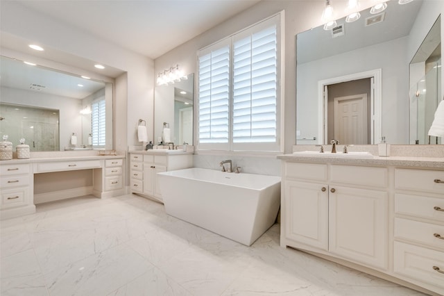 bathroom with a freestanding tub, plenty of natural light, a sink, and marble finish floor