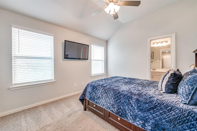 carpeted bedroom featuring baseboards, a ceiling fan, ensuite bathroom, and lofted ceiling