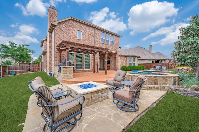 rear view of house with a fenced backyard, a chimney, an outdoor hot tub, brick siding, and an outdoor fire pit