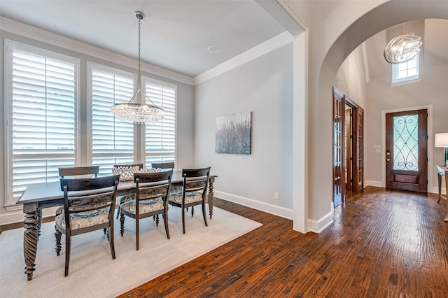 dining space with baseboards, arched walkways, dark wood finished floors, and a chandelier