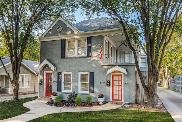 view of front of home with french doors, fence, a ceiling fan, and a balcony