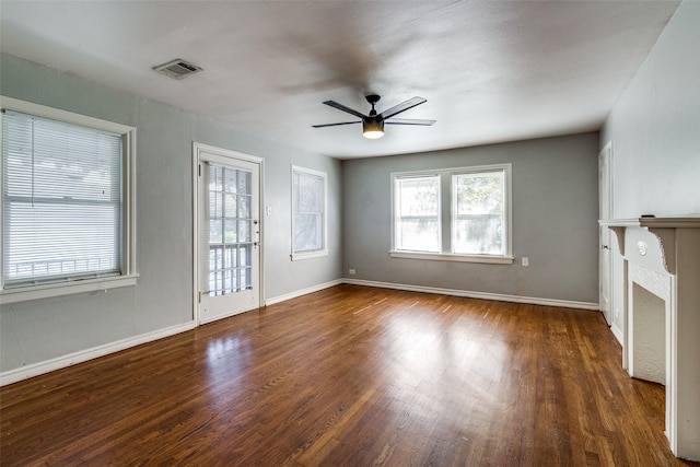 unfurnished living room featuring a ceiling fan, visible vents, plenty of natural light, and wood finished floors