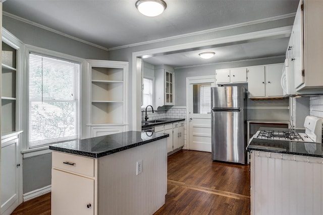 kitchen with white cabinets, dark wood-style flooring, a sink, freestanding refrigerator, and white range with gas cooktop