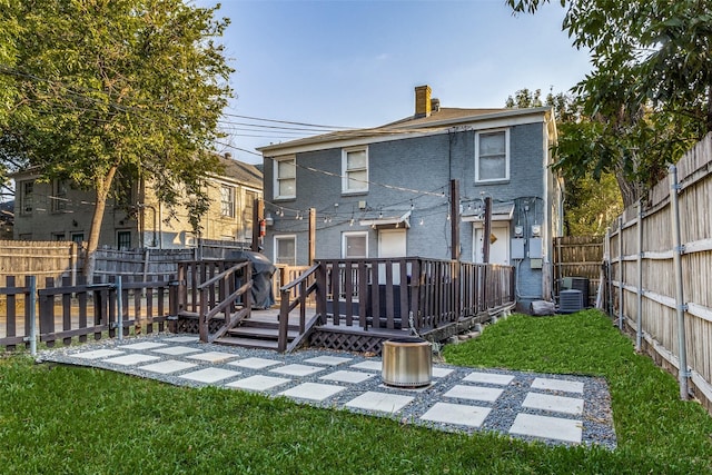 back of house with a wooden deck, a fenced backyard, a chimney, central air condition unit, and a yard