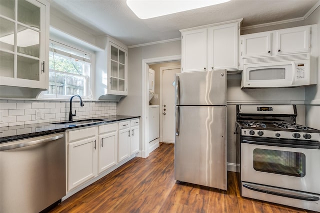 kitchen featuring white cabinets, a sink, stainless steel appliances, decorative backsplash, and dark wood-style floors