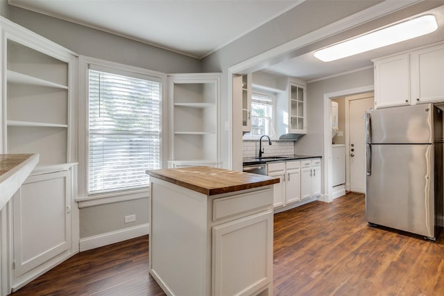 kitchen with a sink, white cabinetry, appliances with stainless steel finishes, and butcher block counters