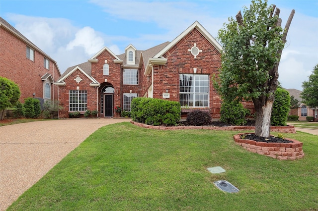 traditional-style home featuring brick siding and a front lawn