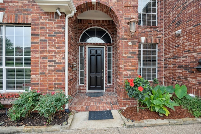 view of exterior entry with brick siding
