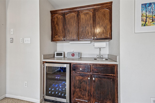 bar with indoor wet bar, beverage cooler, baseboards, and a sink