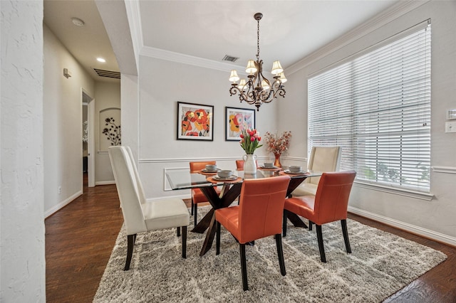 dining room featuring visible vents, wood finished floors, baseboards, a chandelier, and ornamental molding