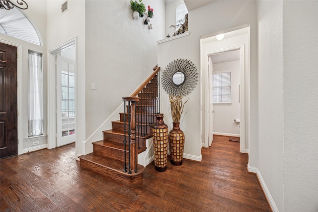 entrance foyer featuring visible vents, wood finished floors, and a healthy amount of sunlight