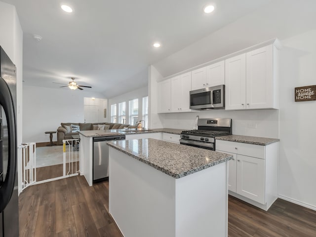 2913 Meadowlands Dr, Forney, TX 75126 - kitchen featuring light stone countertops, appliances with stainless steel finishes, a center island, a ceiling fan, and dark wood-style floors