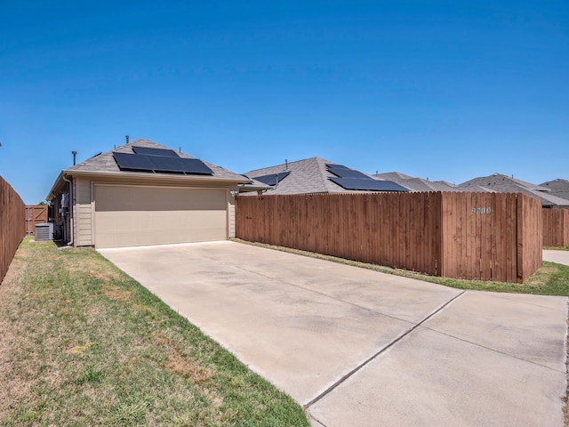 2913 Meadowlands Dr, Forney, TX 75126 - view of side of property featuring a garage, concrete driveway, fence, and solar panels
