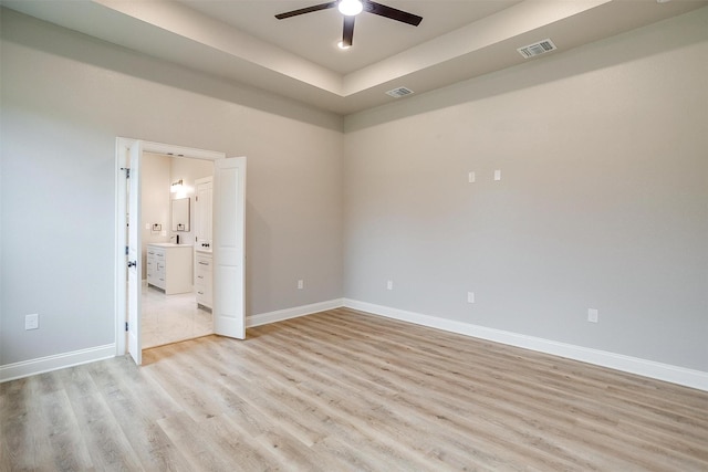 spare room featuring ceiling fan, visible vents, baseboards, and light wood-type flooring