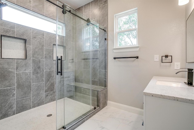 full bathroom featuring baseboards, a shower stall, marble finish floor, and vanity