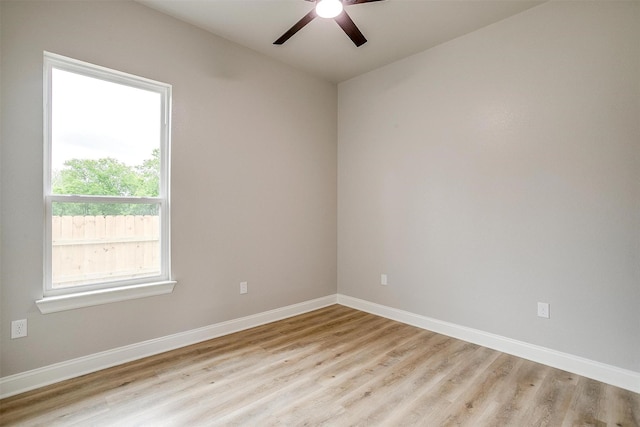 empty room featuring a ceiling fan, baseboards, and light wood-type flooring