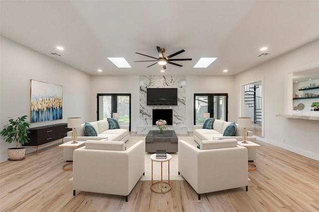 7335 Royal Cir, Dallas, TX 75230 - living room featuring visible vents, a fireplace, wood finished floors, and a skylight
