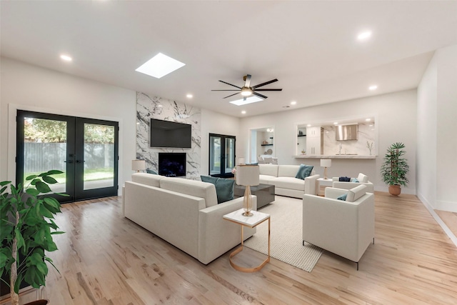 7335 Royal Cir, Dallas, TX 75230 - living room with ceiling fan, light wood-style floors, french doors, recessed lighting, and a skylight