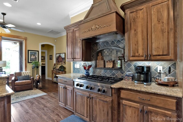 1860 Leonard Rd, Shreveport, LA 71115 - kitchen with ornamental molding, stainless steel gas cooktop, a ceiling fan, tasteful backsplash, and custom exhaust hood