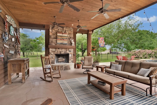 view of patio with ceiling fan, an outdoor living space with a fireplace, and fence