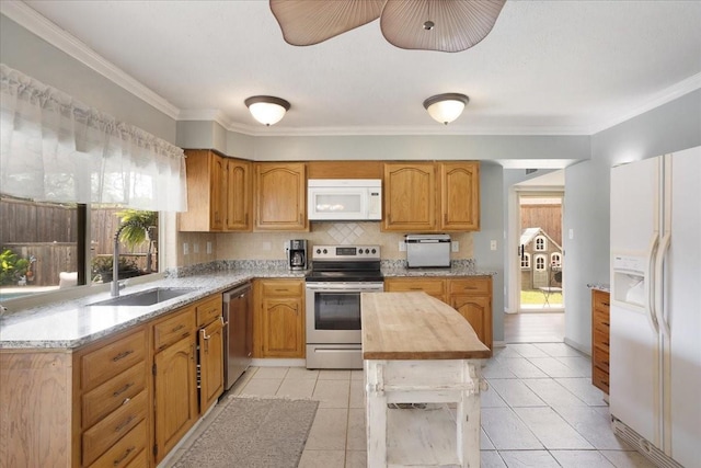 2231 E Peters Colony Rd, Carrollton, TX 75007 - kitchen featuring appliances with stainless steel finishes, a sink, crown molding, tasteful backsplash, and light tile patterned floors