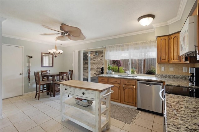 2231 E Peters Colony Rd, Carrollton, TX 75007 - kitchen featuring appliances with stainless steel finishes, healthy amount of natural light, light tile patterned floors, brown cabinets, and ornamental molding