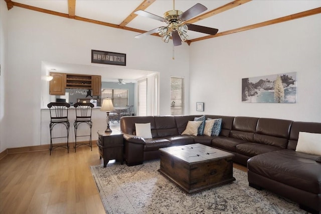 2231 E Peters Colony Rd, Carrollton, TX 75007 - living room featuring a ceiling fan, light wood-style floors, baseboards, and a high ceiling
