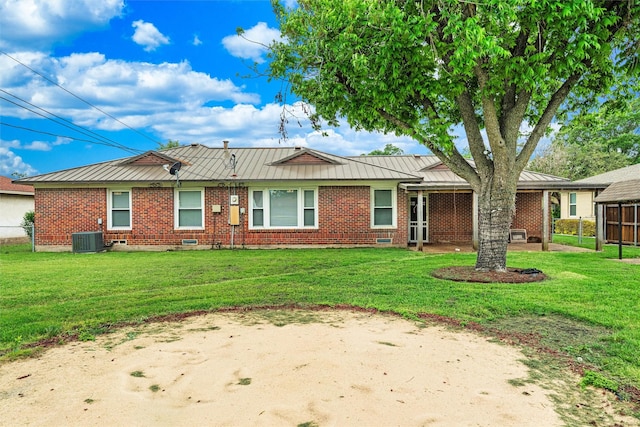 view of front of property with a standing seam roof, metal roof, central air condition unit, brick siding, and a front lawn