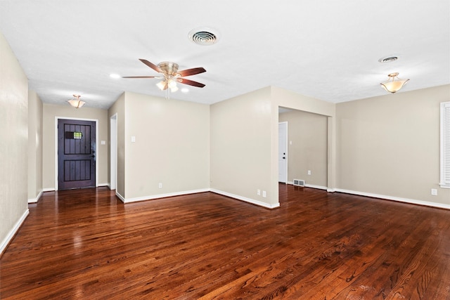 empty room with visible vents, baseboards, ceiling fan, and wood finished floors