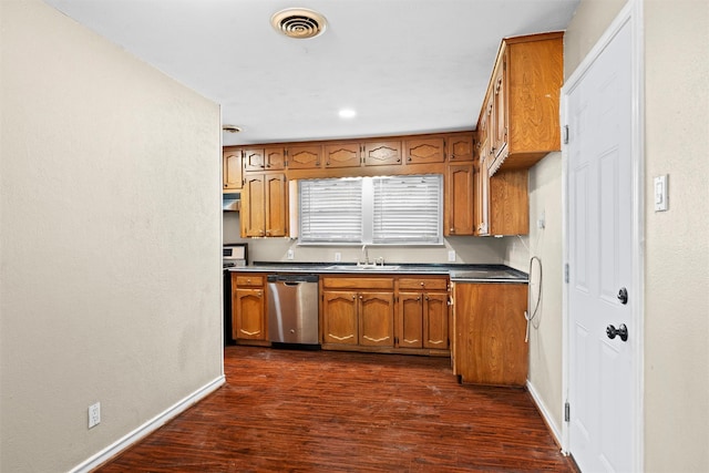 kitchen featuring brown cabinets, dark wood-style flooring, a sink, dishwasher, and baseboards