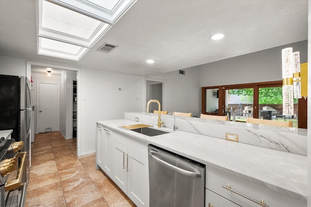 kitchen featuring visible vents, appliances with stainless steel finishes, a sink, light stone counters, and white cabinets