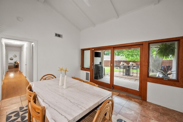 dining area featuring beamed ceiling, high vaulted ceiling, visible vents, and light tile patterned floors