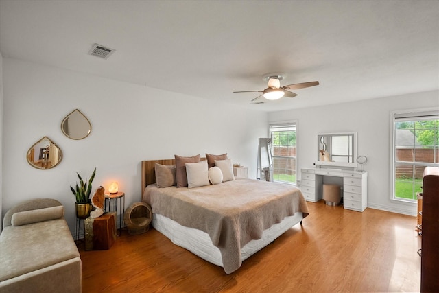 bedroom with visible vents, ceiling fan, multiple windows, and light wood-type flooring