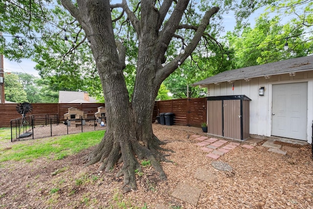view of yard featuring a fenced backyard, a shed, and an outbuilding