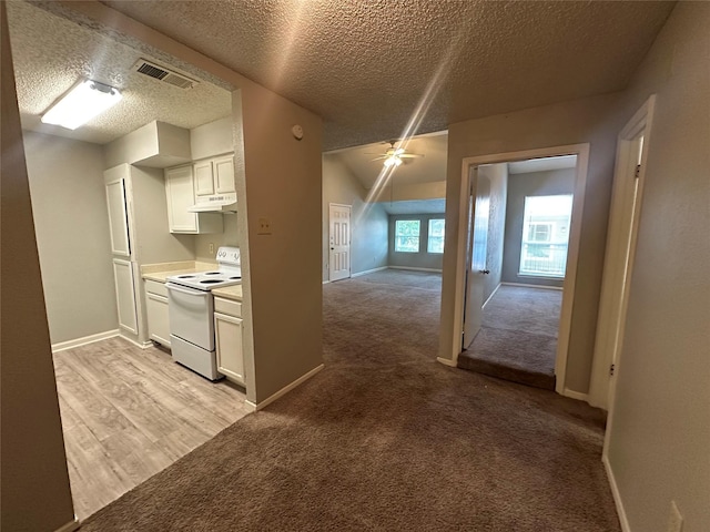 kitchen with visible vents, electric range, a textured ceiling, white cabinetry, and under cabinet range hood