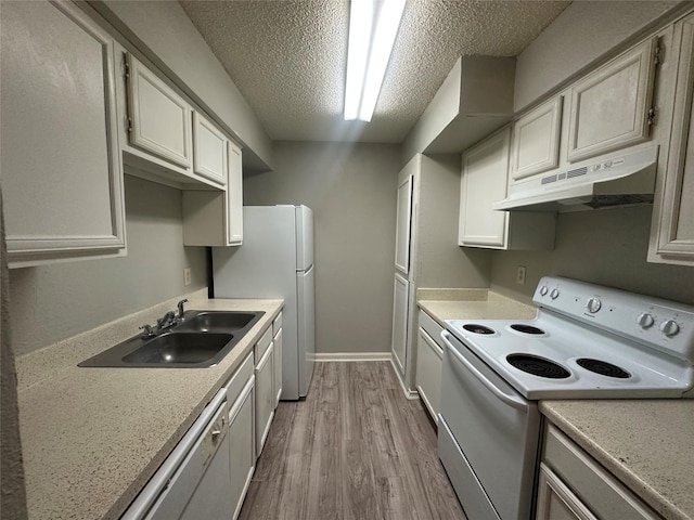 kitchen with a sink, white appliances, light countertops, wood finished floors, and under cabinet range hood