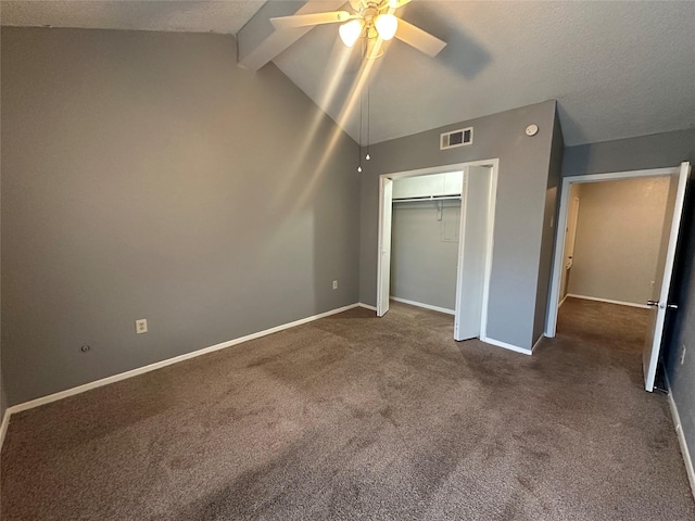 unfurnished bedroom featuring a closet, a ceiling fan, dark colored carpet, baseboards, and lofted ceiling with beams
