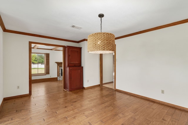 interior space with visible vents, light wood-style flooring, crown molding, and baseboards